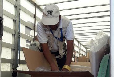 Thevanathan Nadesapillai, UN Volunteer with the United Nations Monitoring Mechanism for Syria (UNMM), checking the contents of a shipment of the International Organization for Migration (IOM) in Turkey.