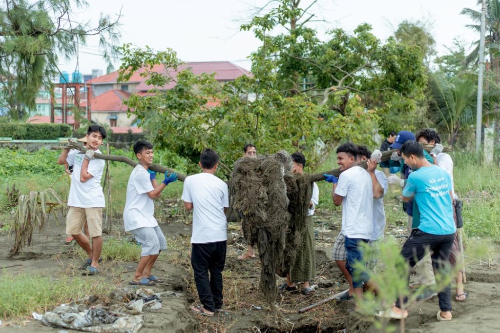 Bhone Myint Aung, (first on the right in blue T-shirt), national UN Volunteer, Triple Nexus Coordinator with the UNDP-Sittwe Rakhine field office participates in a clean-up volunteering activity following the Cyclone Mocha in Sittwe province, Myanmar. During the activity, large fishing nets, plastic waste, and remains of destroyed trees were collected along the Sittwe strand street.) ©️UNDP Myanmar