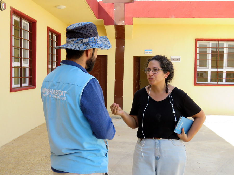 A man and woman talking in front of a building.