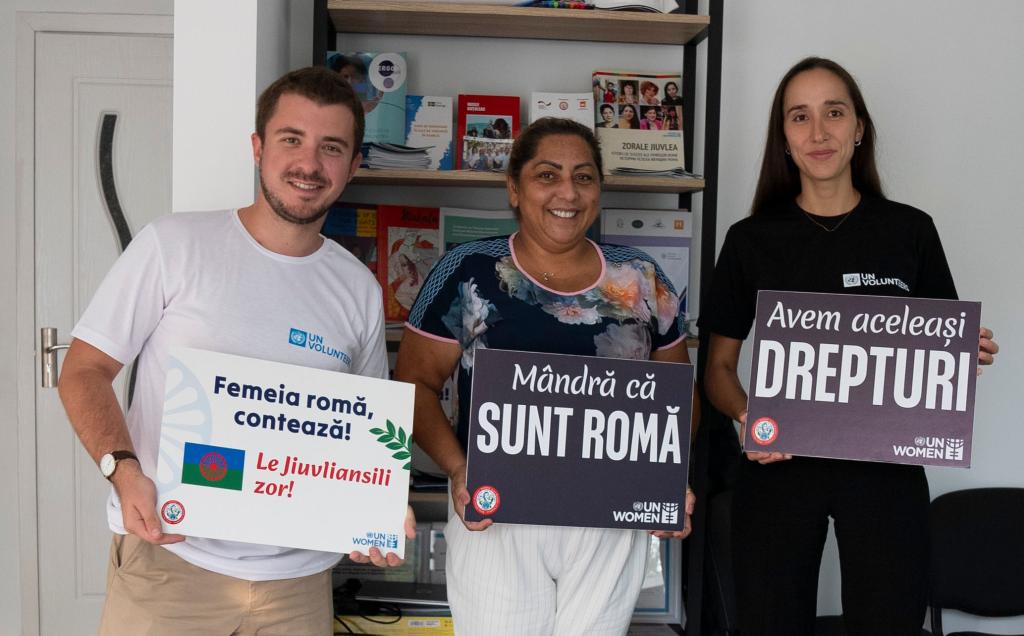 UN Volunteers Laure and Mihail, Roma mediator and activist Elena Sirbu are holding cards supporting Roma rights.