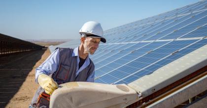 Technician inspects solar panels at a renewable energy facility.