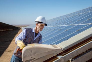 Technician inspects solar panels at a renewable energy facility.