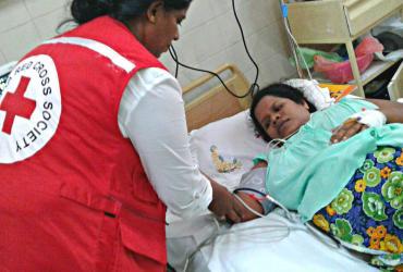 Un volontaire de la Croix-Rouge au chevet d’un patient dans un hôpital sri lankais (2017).