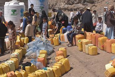 Families line up for water distribution in Yemen.