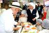 WFP official and a chef teaching children about healthy food choices.