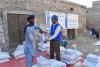 Wajahat Hussain Soomro (right), Community UN Volunteer, Monitoring Assistant with WFP Pakistan distributes food ratio to the affected people in Larkana district