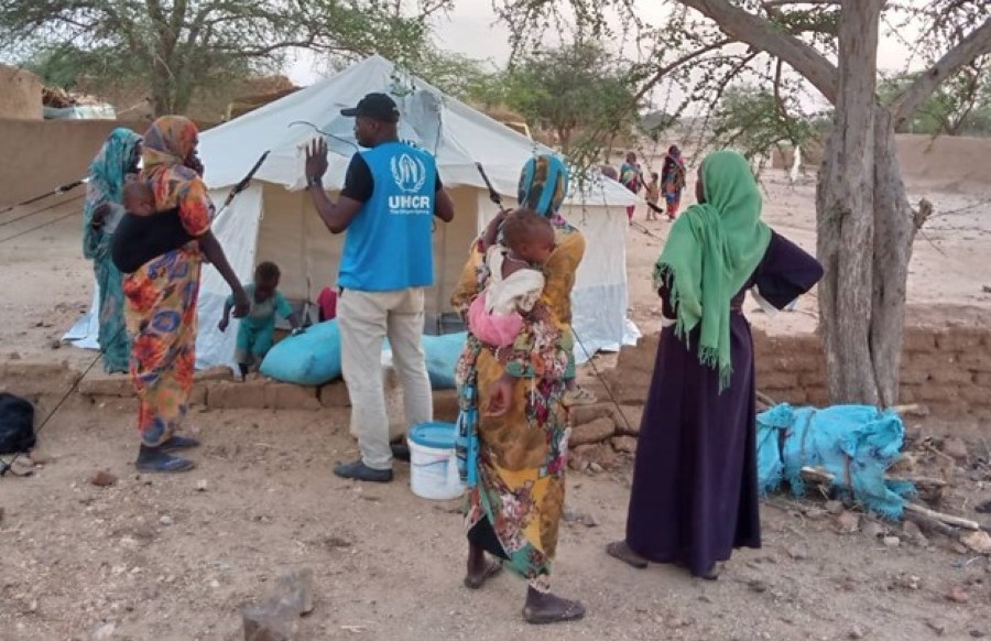 UN Volunteer Franck Ndohessengar (in blue) sensitizing Sudanese refugee women in the Kounoungou camp in May 2023. He explains proper security precautions around emergency tents, emphasizing the necessity of maintaining a safe distance of five meters when lighting a fire.