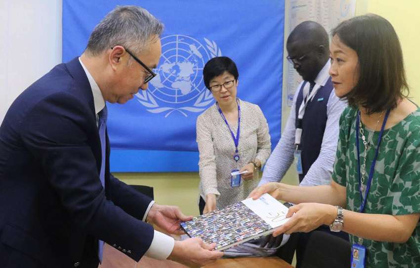 Kyoko Yokosuka (left), Deputy Executive Coordinator, handing over UNV's 50th anniversary photo book to Mr Guang Cong, Deputy Special Representative for South Sudan and Deputy Head of UNMISS.