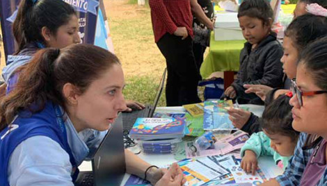 Claire Hannappe (front left), international United Nations Specialist Volunteer funded by France, Protection
						Specialist (child trafficking), IOM, talks with women and children in Peru.